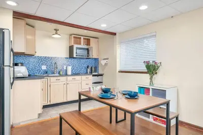 a kitchen with a wooden table and a small table with blue dishes on it at The Lux in Lakewood. Minutes from Red Rocks. Hikes in Lakewood