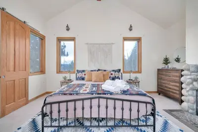 a bedroom with a bed in a room with windows at Hide-A-Way. Private Hot Tub Pets Welcome. in Evergreen