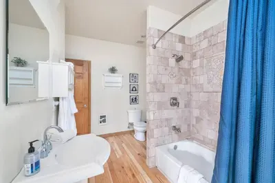 a bathroom with a tub and a toilet and a sink at Hide-A-Way. Private Hot Tub Pets Welcome. in Evergreen