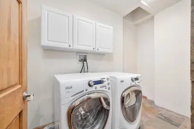 a washer and dryer in a white laundry room at Hide-A-Way. Private Hot Tub Pets Welcome. in Evergreen