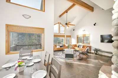 a dining room and living room with a table and chairs at Hide-A-Way. Private Hot Tub Pets Welcome. in Evergreen