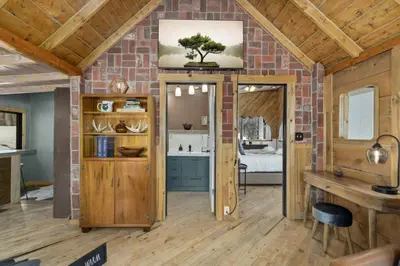 a living room with a brick wall and a doorway at The Tyrolean Cabin. Panoramic Views. Hot Tub. in Golden