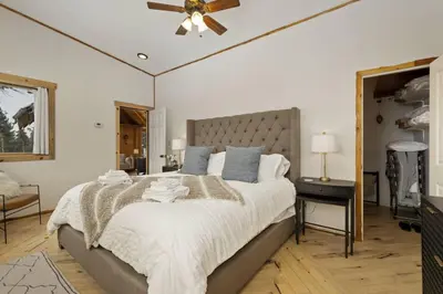 a bedroom with a large bed and a ceiling fan at The Tyrolean Cabin. Panoramic Views. Hot Tub. in Golden