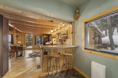 a kitchen and living room of a tiny house at The Tyrolean Cabin. Panoramic Views. Hot Tub. in Golden