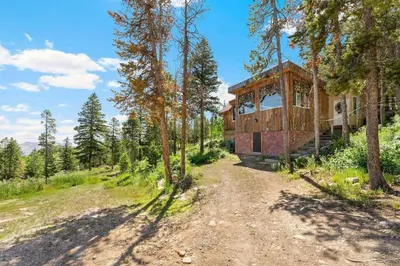 a tree house in the woods with a dirt road at The Tyrolean Cabin. Panoramic Views. Hot Tub. in Golden