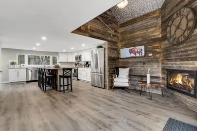 a living room with a fireplace and a kitchen at Cabin by North Clear Creek. Private Hot Tub. Pets in Black Hawk