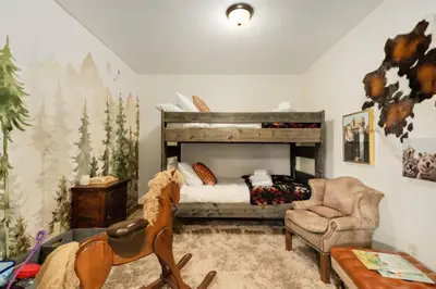 a bedroom with a bed and a chair at New. Top of the World Lodge. Hot tub. Theater. in Evergreen
