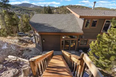 a home with a wooden walkway leading to the front door at New. Top of the World Lodge. Hot tub. Theater. in Evergreen
