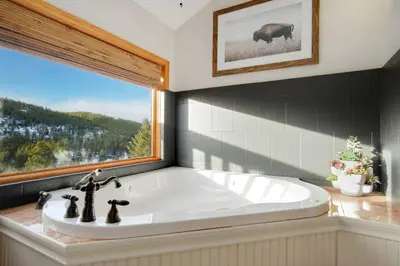 a large bath tub in a bathroom with a window at New. Top of the World Lodge. Hot tub. Theater. in Evergreen