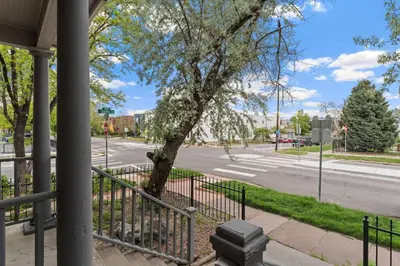 a fence with a tree next to a street at New Classic Comfortable Rino Escape. Pets Welcome in Denver