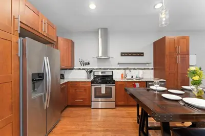 a kitchen with a table and a stainless steel refrigerator at New Classic Comfortable Rino Escape. Pets Welcome in Denver