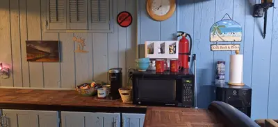 a kitchen with a counter top with a microwave at Tiki Bar in The Basement in Arvada