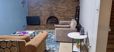 a living room with two couches and a fireplace at Tiki Bar in The Basement in Arvada