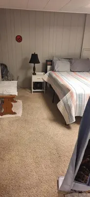 a bedroom with two beds and a table with a lamp at Tiki Bar in The Basement in Arvada