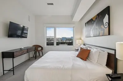 a bedroom with a bed and a desk and a window at The Espadin LoHi Collection in Denver