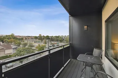 a balcony with a desk and a view of a city at The Espadin LoHi Collection in Denver