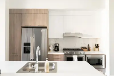 a kitchen with a sink and a stainless steel refrigerator at The Espadin LoHi Collection in Denver