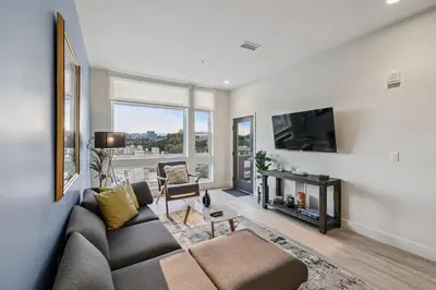 a living room with a couch and a tv at The Espadin LoHi Collection in Denver