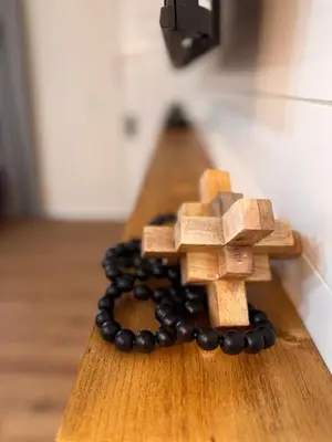 a wooden rosary on a wooden table with black beads at Beautifully Renovated OneBedroom Apt with Two Beds in Littleton