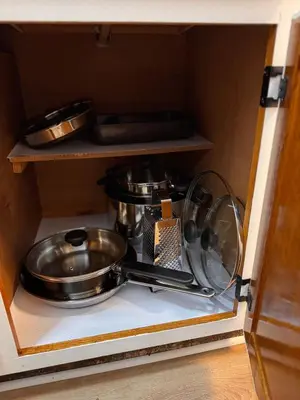 a cabinet with some pots and pans in it at Beautifully Renovated OneBedroom Apt with Two Beds in Littleton