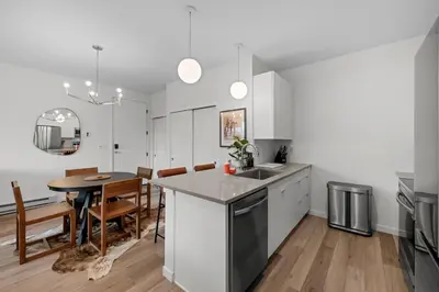 a kitchen with white cabinets and a table and chairs at 301 W Meadow Mile #3 in Fraser