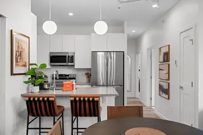 a kitchen with a refrigerator and a table with chairs at 301 W Meadow Mile #3 in Fraser