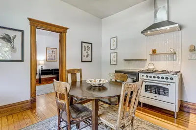 a kitchen with a table and a stove at Downtown Walkability - The Purple House in Berthoud