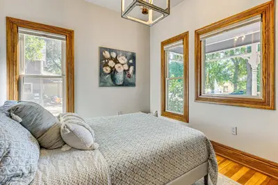 a bedroom with a bed and two windows at Downtown Walkability - The Purple House in Berthoud