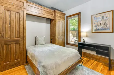 a bedroom with a bed and a desk in it at Downtown Walkability - The Purple House in Berthoud