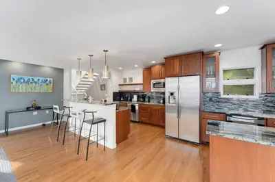 a large kitchen with wooden cabinets and stainless steel appliances at New Denver Escape. 3 bedroom. Near everything. in Denver