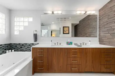a bathroom with a tub and a large mirror at New Denver Escape. 3 bedroom. Near everything. in Denver