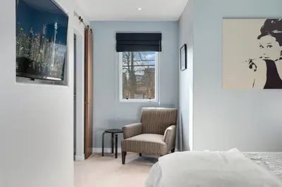 a bedroom with a bed and a chair and a window at New Denver Escape. 3 bedroom. Near everything. in Denver