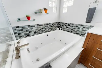 a white bath tub in a bathroom with tiles at New Denver Escape. 3 bedroom. Near everything. in Denver