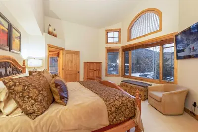 a bedroom with a bed and a chair and a window at 24 Autumn Brook townhouse in Dillon