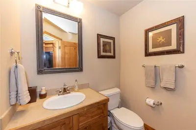 a bathroom with a sink and a toilet and a mirror at 24 Autumn Brook townhouse in Dillon