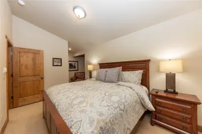 a bedroom with a bed and a night stand with a lamp at 24 Autumn Brook townhouse in Dillon
