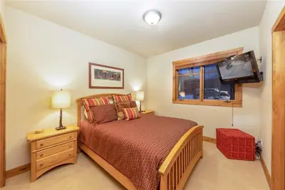 a bedroom with a bed and a tv on the wall at 24 Autumn Brook townhouse in Dillon