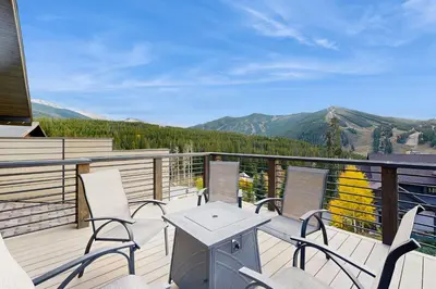 a balcony with a table and chairs and mountains at Lakota Northwoods Luxury Villa 308 in Winter Park