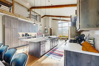 a large kitchen with wooden cabinets and blue chairs at Lakota Northwoods Luxury Villa 308 in Winter Park