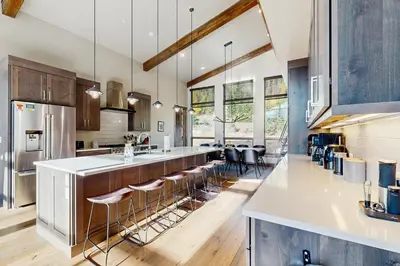 a kitchen with a large island with bar stools at Lakota Northwoods Luxury Villa 308 in Winter Park