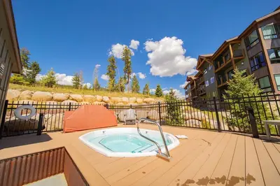 a hot tub on the deck of a building at 1 bedroom apartment free electric charger Keystone in Keystone