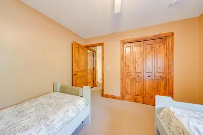 a bedroom with two beds and wooden doors at Loveland Peaks Retreat Family Home 3 Mi to Dtwn! in Loveland