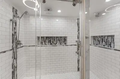 a glass shower in a bathroom with white tiles at Lake Cliffe 305 Building A in Dillon
