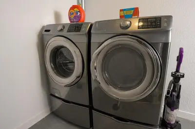 a washing machine is sitting next to a wall at Sleeps 16 Hot Tub Arcade Movie Theater Pool Table in Westminster