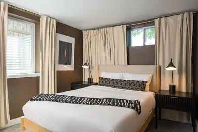 a bedroom with a large bed and two windows at Sleeps 16 Hot Tub Arcade Movie Theater Pool Table in Westminster