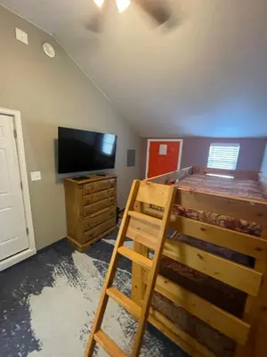 a bedroom with a bunk bed and a flat screen tv at Cabins on Main Longmont in Longmont