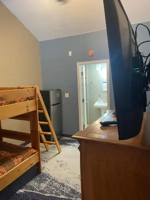 a bedroom with a bunk bed and a tv on a dresser at Cabins on Main Longmont in Longmont