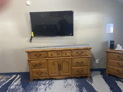 a wooden dresser with a flat screen tv on a wall at Cabins on Main Longmont in Longmont