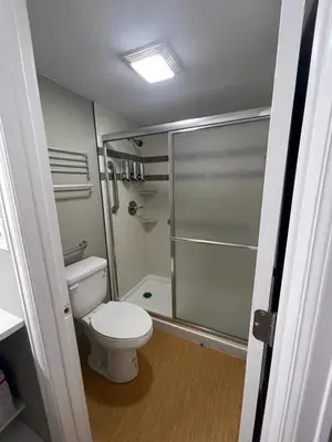 a bathroom with a toilet and a glass shower at Cabins on Main Longmont in Longmont