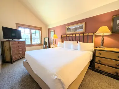 a bedroom with a large bed and a television at Expedition Station 8635 by SummitCove Lodging in Keystone